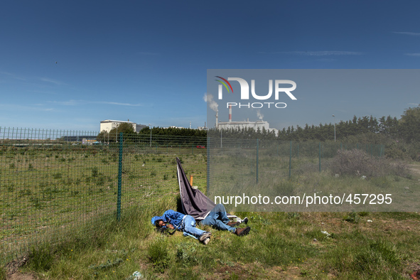 Migrants sleep in a field after spending the night attempting to jump inside trucks that will be taken to Dover in the next Ferri. Calais, F...