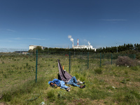 Migrants sleep in a field after spending the night attempting to jump inside trucks that will be taken to Dover in the next Ferri. Calais, F...