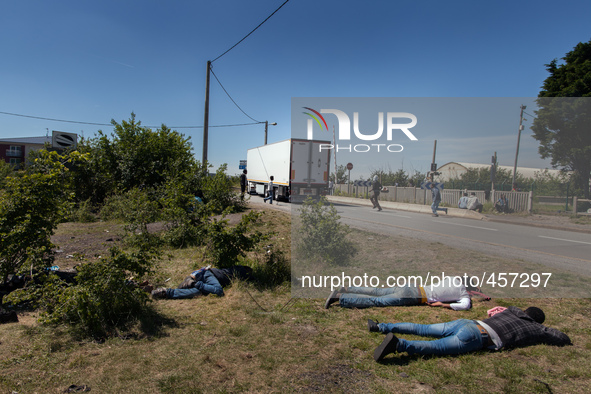 While some migrants rest after a sleepless night, others  run after a passing by truck to try to jump inside the cargo compartment. These at...