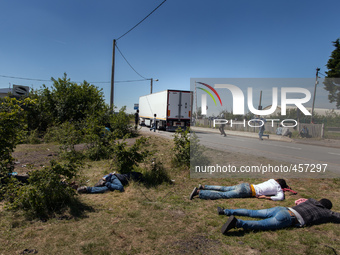 While some migrants rest after a sleepless night, others  run after a passing by truck to try to jump inside the cargo compartment. These at...