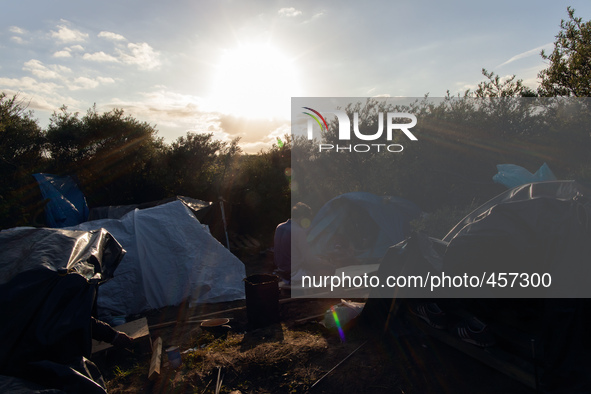 A man prays in a base camp in an area known as "the jungle" which is closer to the port than the official migrant camp in Calais and offers...