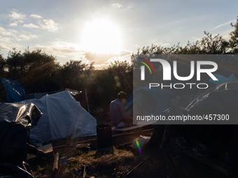 A man prays in a base camp in an area known as "the jungle" which is closer to the port than the official migrant camp in Calais and offers...