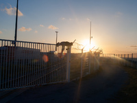 A migrant is seen climbing over a barrier to access the truck parking lot as the sun sets. Calais, France, June 2014.

For the last 20 yea...