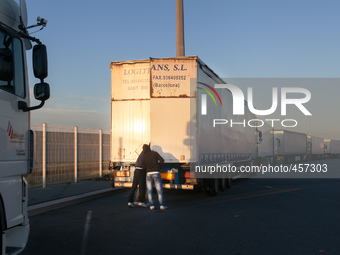 A couple of migrants examine the interior of a truck inside port's the parking lot. The best way to find out if vehicle is heading towards t...