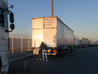 A couple of migrants examine the interior of a truck inside port's the parking lot. The best way to find out if vehicle is heading towards t...