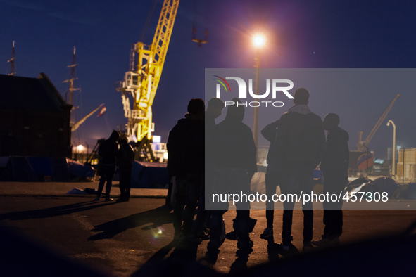 Migrants discuss in the camp at night. Calais, France, June 2014.

For the last 20 years the French city of Calais, with links from the Eu...