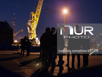 Migrants discuss in the camp at night. Calais, France, June 2014.

For the last 20 years the French city of Calais, with links from the Eu...