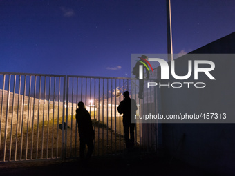 Three migrants start jumping the fences to access the port's truck parking lot. Calais, France, June 2014.

For the last 20 years the Fren...