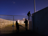 Three migrants start jumping the fences to access the port's truck parking lot. Calais, France, June 2014.

For the last 20 years the Fren...