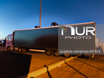 Migrants on top of a truck try to access the container by cutting a hole on the lining. Calais, France, June 2014.

For the last 20 years...