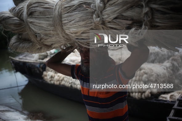 Labourers carry jute from a boat to a truck to send it in the capital Dhaka. Photo has taken on 26 July 2019 from Kurigram, Bangladesh.  