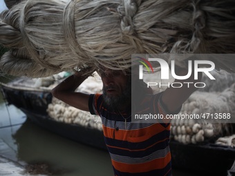 Labourers carry jute from a boat to a truck to send it in the capital Dhaka. Photo has taken on 26 July 2019 from Kurigram, Bangladesh.  (