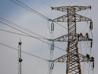 Operators work on a high voltage tower in Jakarta, Indonesia, July 27, 2019.  (