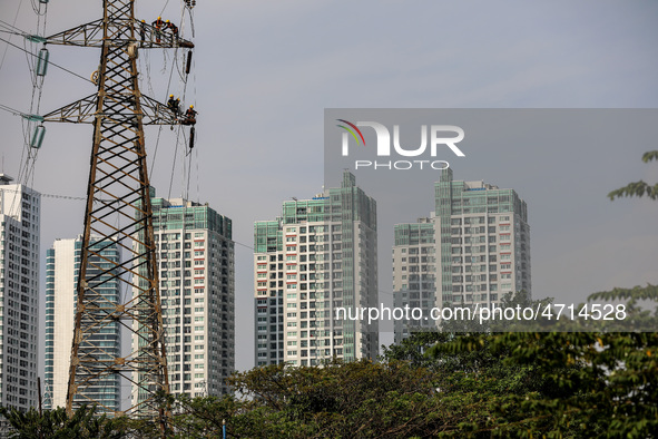 Operators work on a high voltage tower in Jakarta, Indonesia, July 27, 2019.  