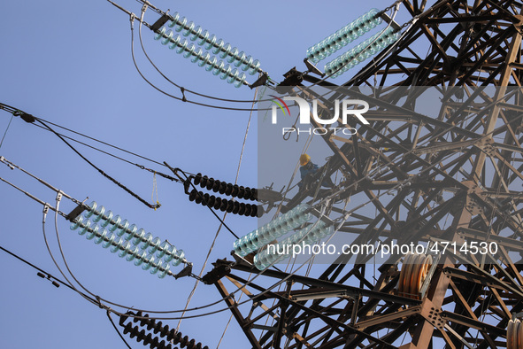 Operators work on a high voltage tower in Jakarta, Indonesia, July 27, 2019.  