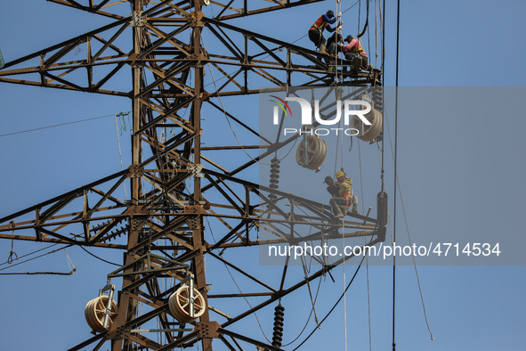 Operators work on a high voltage tower in Jakarta, Indonesia, July 27, 2019.  