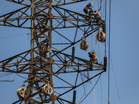 Operators work on a high voltage tower in Jakarta, Indonesia, July 27, 2019.  (