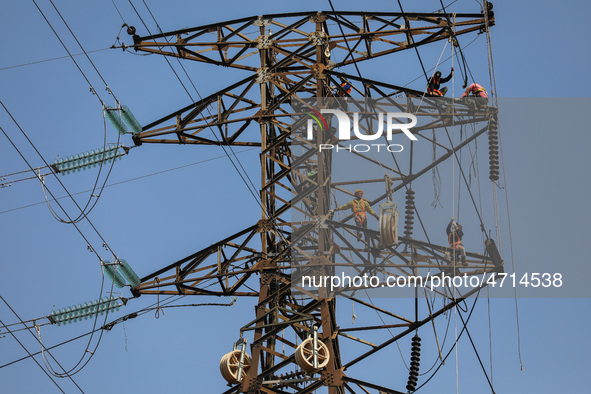 Operators work on a high voltage tower in Jakarta, Indonesia, July 27, 2019.  