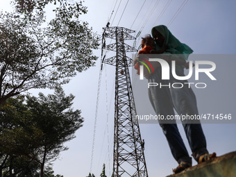 Operators work on a high voltage tower in Jakarta, Indonesia, July 27, 2019.  (