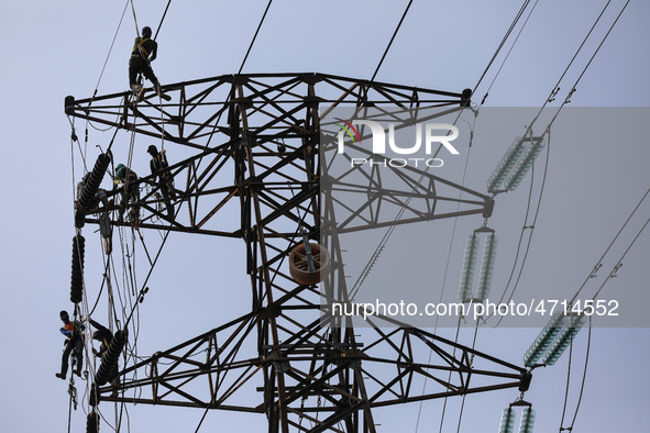 Operators work on a high voltage tower in Jakarta, Indonesia, July 27, 2019.  