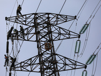 Operators work on a high voltage tower in Jakarta, Indonesia, July 27, 2019.  (