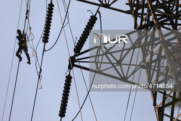 Operators work on high voltage power lines in Jakarta, Indonesia, July 27, 2019.  