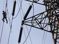 Operators work on high voltage power lines in Jakarta, Indonesia, July 27, 2019.  (