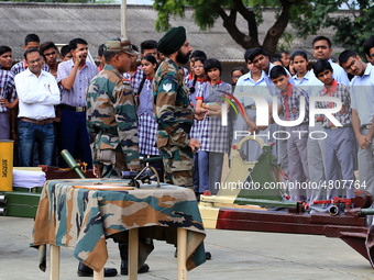 Indian school students take a close look at the various defence equipment during an exhibition organised by the Indian Army in Ajmer, Rajast...