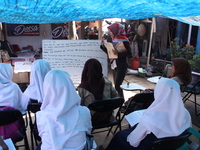 Cijeruk 1 Junior High School students openly study in the yard of a resident's house with a tarpaulin roof in Palasari Village, Bogor Regenc...