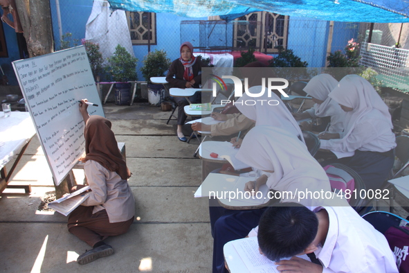 Cijeruk 1 Junior High School students openly study in the yard of a resident's house with a tarpaulin roof in Palasari Village, Bogor Regenc...