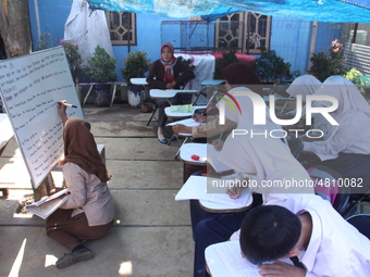 Cijeruk 1 Junior High School students openly study in the yard of a resident's house with a tarpaulin roof in Palasari Village, Bogor Regenc...