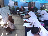 Cijeruk 1 Junior High School students openly study in the yard of a resident's house with a tarpaulin roof in Palasari Village, Bogor Regenc...