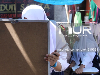 Cijeruk 1 Junior High School students openly study in the yard of a resident's house with a tarpaulin roof in Palasari Village, Bogor Regenc...