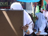 Cijeruk 1 Junior High School students openly study in the yard of a resident's house with a tarpaulin roof in Palasari Village, Bogor Regenc...