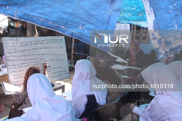 Cijeruk 1 Junior High School students openly study in the yard of a resident's house with a tarpaulin roof in Palasari Village, Bogor Regenc...