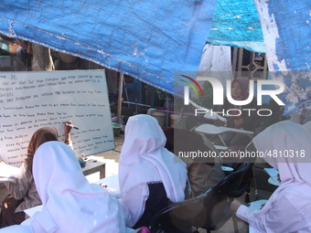 Cijeruk 1 Junior High School students openly study in the yard of a resident's house with a tarpaulin roof in Palasari Village, Bogor Regenc...