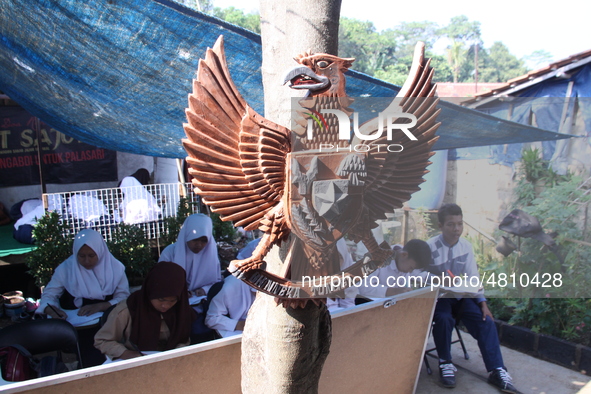 Cijeruk 1 Junior High School students openly study in the yard of a resident's house with a tarpaulin roof in Palasari Village, Bogor Regenc...