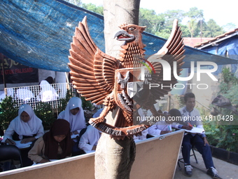 Cijeruk 1 Junior High School students openly study in the yard of a resident's house with a tarpaulin roof in Palasari Village, Bogor Regenc...