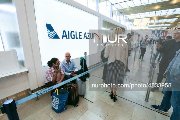 Passengers wait in front of the French airline Aigle Azur’s reception desk, without any employees, at Orly airport, France  on September 6,...