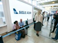 Passengers wait in front of the French airline Aigle Azur’s reception desk, without any employees, at Orly airport, France  on September 6,...