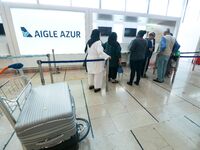 Passengers wait in front of the French airline Aigle Azur’s reception desk, without any employees, at Orly airport, France  on September 6,...