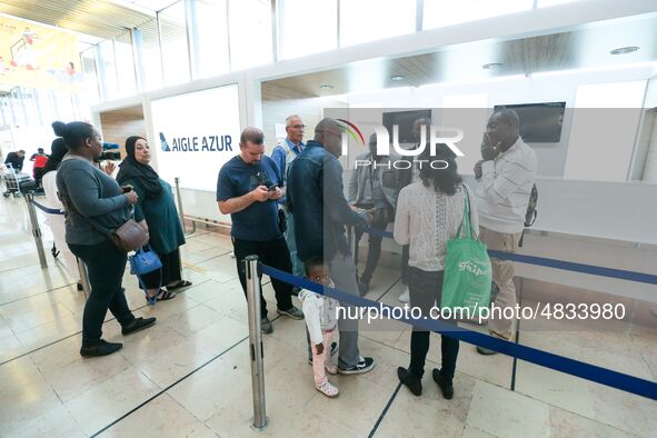 Passengers wait in front of the French airline Aigle Azur’s reception desk, without any employees, at Orly airport, France  on September 6,...