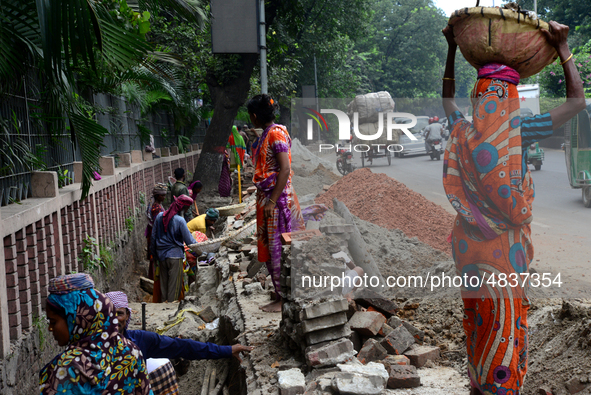 Bangladeshi men and women day laborer works in a road construction site in Dhaka, Bangladesh, on September 7, 2019. 