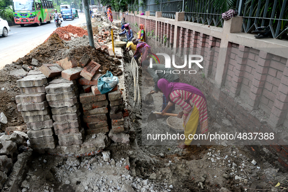 Bangladeshi men and women day laborer works in a road construction site in Dhaka, Bangladesh, on September 7, 2019. 