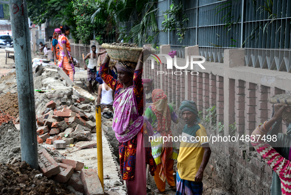 Bangladeshi men and women day laborer works in a road construction site in Dhaka, Bangladesh, on September 7, 2019. 