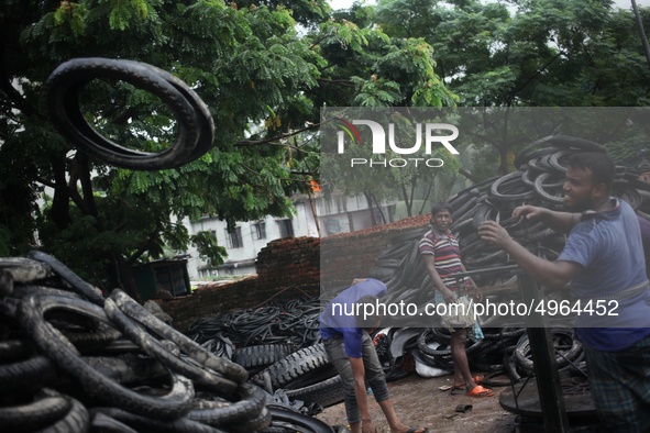 Workers seen handling pieces of old tyres to be recycled in Dhaka,  Bangladesh on 07 October 2019. 