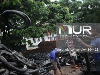 Workers seen handling pieces of old tyres to be recycled in Dhaka,  Bangladesh on 07 October 2019. (