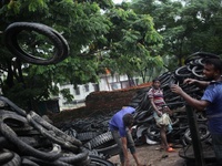 Workers seen handling pieces of old tyres to be recycled in Dhaka,  Bangladesh on 07 October 2019. (