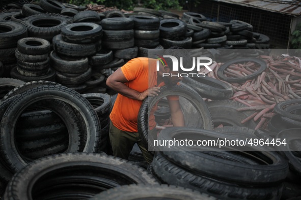 Workers seen handling pieces of old tyres to be recycled in Dhaka,  Bangladesh on 07 October 2019. 