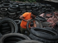 Workers seen handling pieces of old tyres to be recycled in Dhaka,  Bangladesh on 07 October 2019. (